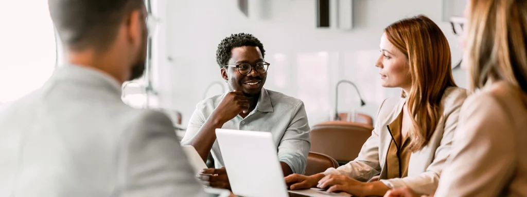 group of coworkers in meeting woman on laptop